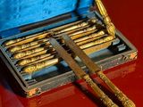 a box with a set of gold spoons and a pair of knives
