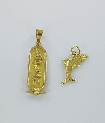 une image représentant un pendentif en or orné d'un oiseau et d'un hiéroglyphe égyptien