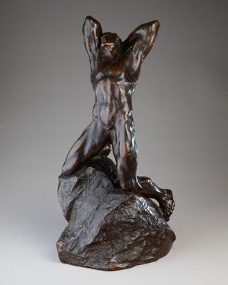 statue en bronze représentant un homme assis sur un rocher, les bras levés
