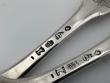 two spoons that are sitting next to each other on a table