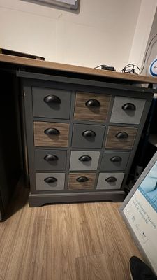 une photo d'un bureau à tiroirs sur lequel est posé un tableau