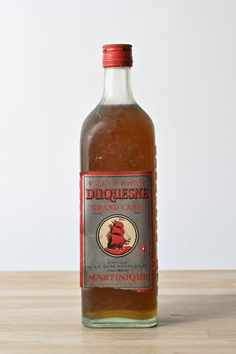 des bouteilles d'alcool posées sur une table en bois, sur fond blanc