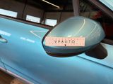 a blue car with a sticker on it ' s side mirror