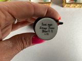 a person holding a small white object with writing on it