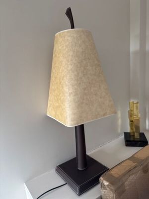 une lampe posée sur une table à côté d'un lit