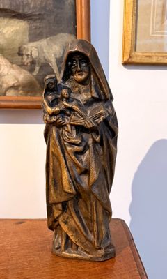 une statue de femme tenant un enfant sur une table