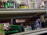 many cans of paint on the shelves in the store