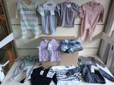 many baby clothes hanging on a wall in a store