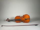 a violin that is sitting on the ground next to a bow
