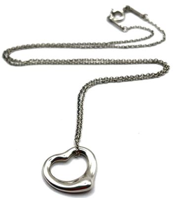 Collier avec un cœur en argent et une chaîne, sur fond blanc