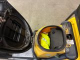 a yellow and black forklift with a yellow bag inside of it