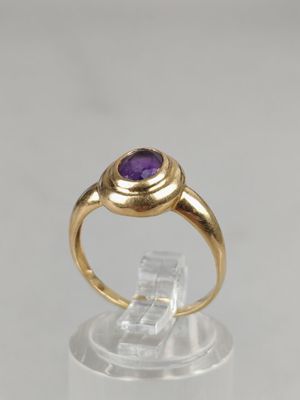 an image of a gold ring with a purple stone in the center