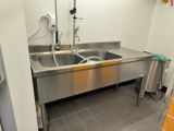 a stainless steel sink with a faucet in the corner