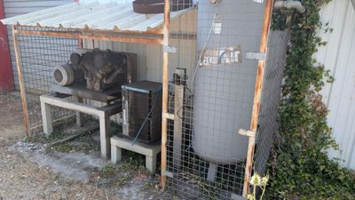 un grand réservoir posé à côté d'une clôture recouverte d'un toit métallique