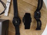 three watches sitting on a wooden table next to a charger