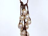 a close up of a necklace with pearls on it