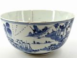 a blue and white bowl with a picture of a boat in the water