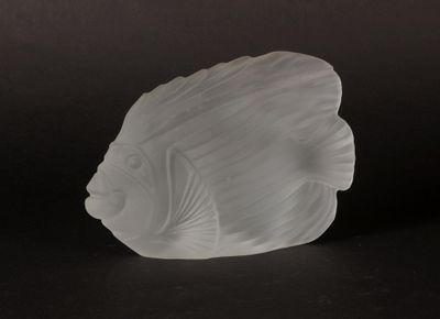 a glass fish that is sitting on a black surface