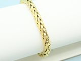 a close up of a gold bracelet sitting on top of a napkin