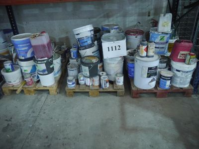 de nombreux seaux de peinture posés sur les palettes dans le garage