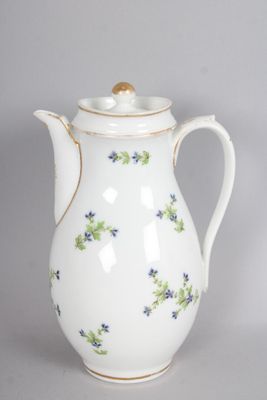 a white coffee pot with blue and green flowers on it