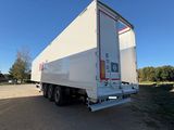 La remorque est garée sur le bord de la route, sur le parking.