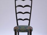 une chaise noire dont l'assise est recouverte d'un tissu à motifs floraux
