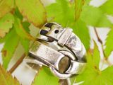 a silver ring that is sitting on top of a leaf