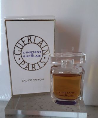 un flacon de parfum posé sur une table à côté d'une boîte