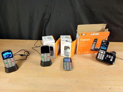several cell phones are lined up on a table next to a box