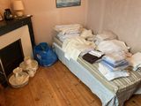 a bed with a lot of clothes on it in a room