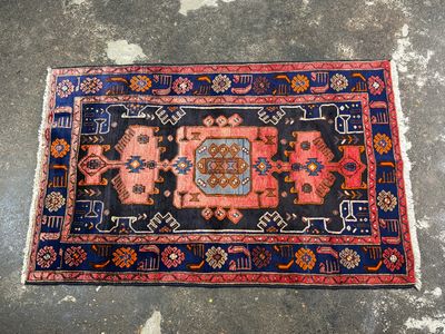 a blue and red rug on a concrete floor