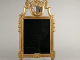 une image représentant un miroir à cadre doré sur lequel est posée une horloge
