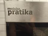 Quelqu'un prend une photo d'un micro-ondes sur lequel est inscrit « Pratica ».