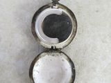 a small silver locke with a black and white picture inside of it