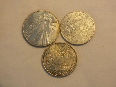 three different coins sitting on top of each other on top of a table