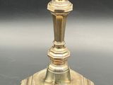 a gold candle holder on a table with a black background