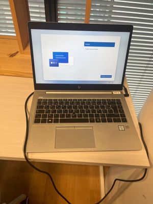 a laptop that is sitting on a desk with a power cord