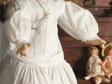a doll that is standing in front of a chest of drawers