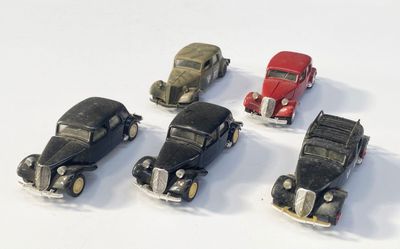 plusieurs petites voitures sont alignées sur une surface blanche