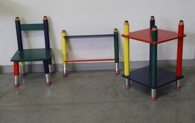 trois chaises et une table fabriquées à partir de crayons