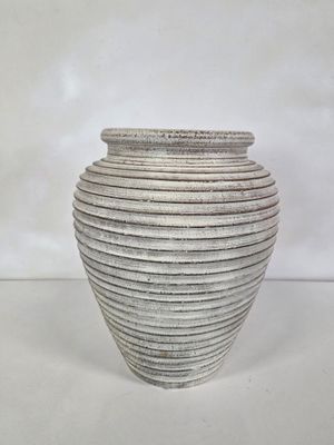 une image représentant un vase blanc posé sur une table
