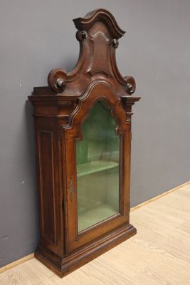 une vieille armoire en bois avec une porte vitrée, dans une pièce