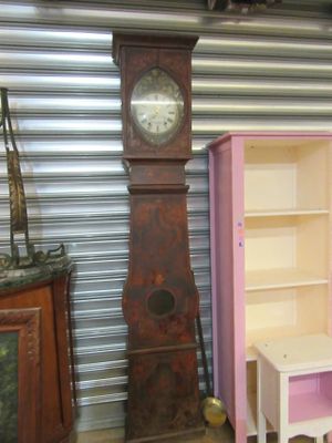 une horloge de parquet à côté d'un meuble rose dans une pièce