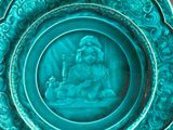 une assiette bleue sur laquelle est représenté un Bouddha