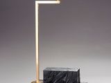 une image représentant une lampe en marbre noir avec un pied doré