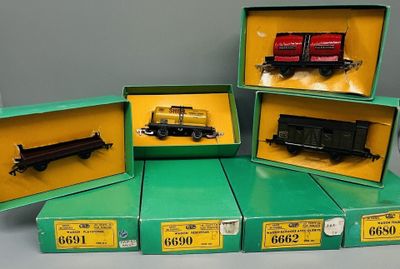 quatre cartons contenant des trains miniatures posés sur une table dans une pièce