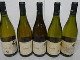 six bottles of wine are lined up on a table