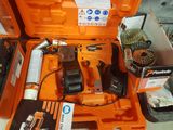 une boîte à outils orange posée par terre et contenant des outils