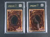 two pca trading cards in plastic cases on a black surface
